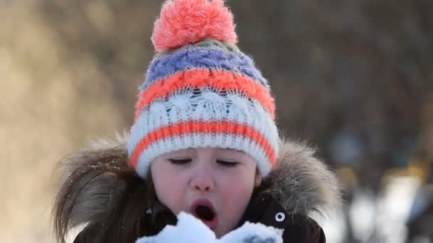 holčička hraje se sněhem v zimě.