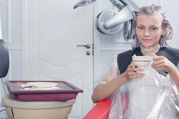 Une blonde femme mourante cheveux dans le salon de coiffure — Photo