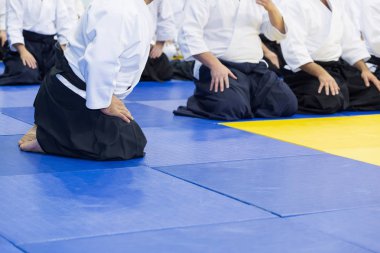 Kimono ve hakama giymiş insanlar dövüş sanatları eğitimi alıyorlar.