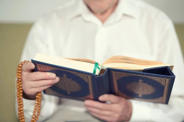 Las manos de un anciano sosteniendo el Corán — Foto de Stock