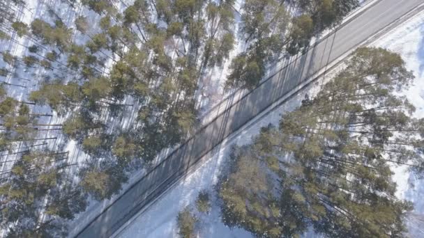 Besneeuwde weg met een rijdende auto in de winter — Stockvideo