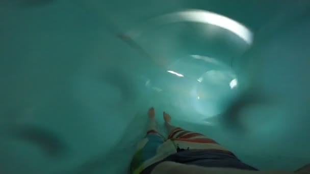 FPV: Молодой человек скользит вниз в аквапарке — стоковое видео