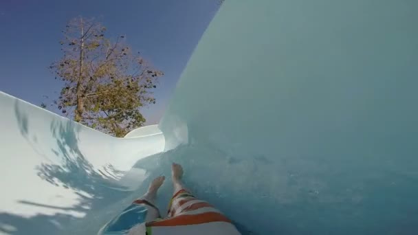 FPV: Joven deslizándose en el parque acuático. Movimiento lento — Vídeos de Stock