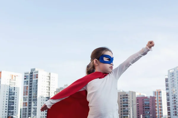 Superhéroe niño contra fondo urbano — Foto de Stock