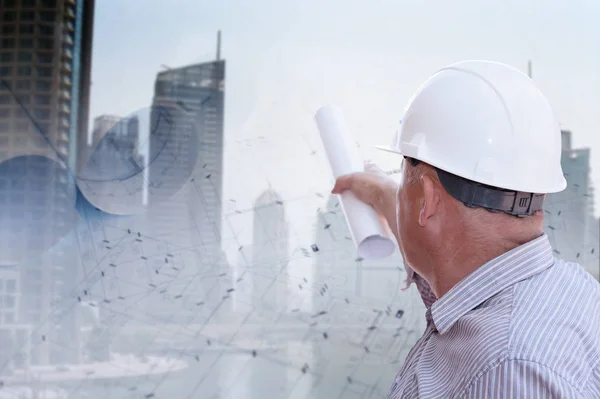 Un ingeniero estudia planos sobre el fondo urbano — Foto de Stock