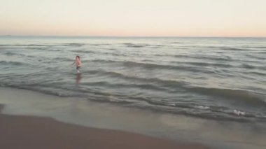 Denizde oynayan küçük kız ve erkek kardeş.