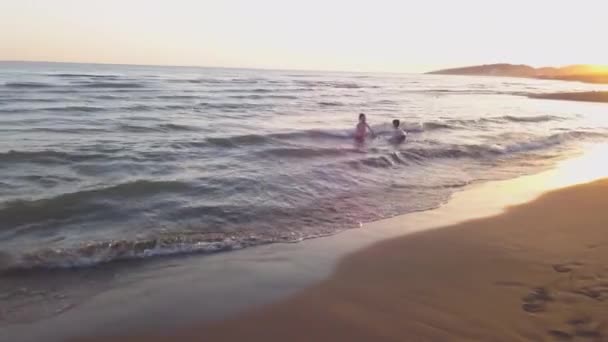 Jeune sœur et frère qui jouent dans la mer — Video