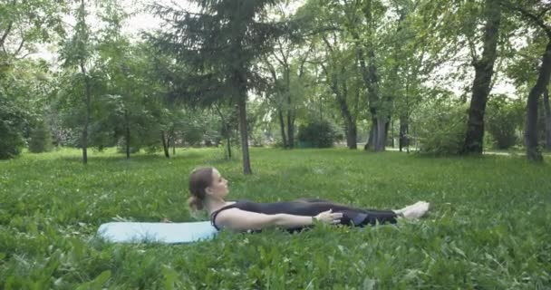 Gyönyörű nő Pilates a zöld parkban — Stock videók