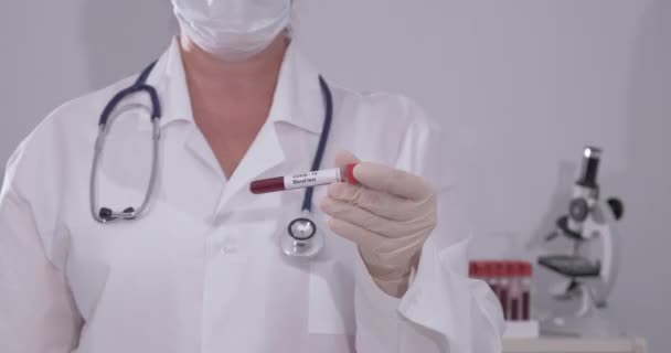 Ковид-19 инфицированных образцов крови в вакуумной трубке в руке ученого врача в исследовательской лаборатории — стоковое видео