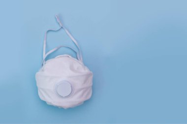Mavi arka planda beyaz tıbbi maske. Kirliliğe, virüse, gribe ve koronavirüse karşı bir koruma