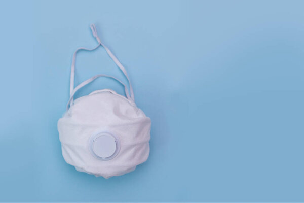 White medical mask on blue background. A protection against pollution, virus, flu and coronavirus