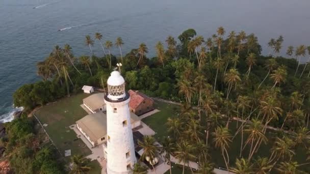 Vista aérea do drone do farol velho de pedra branca localizado na ilha — Vídeo de Stock