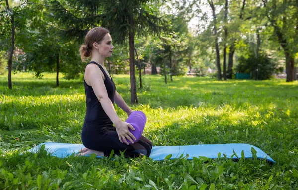 Piękna kobieta robi pilates w zielonym parku — Zdjęcie stockowe