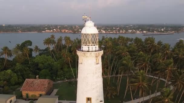 Aerial drone view of the old lighthouse of white stone located on the island — Stock Video
