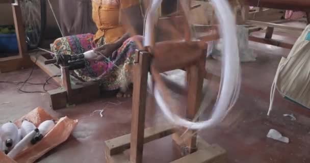 Hands of an old woman using an old spinning wheel to turn wool into yarn — 비디오