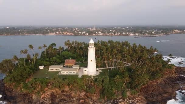 Uitzicht vanuit de lucht op de oude vuurtoren van witte steen op het eiland — Stockvideo