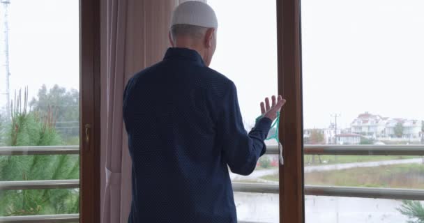 Un vieil homme avec des perles de chapelet priant — Video