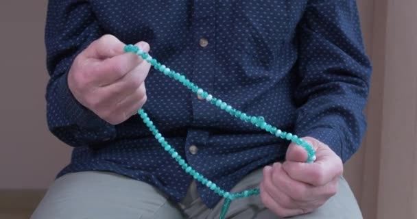 Praying hands of an old man with rosary beads — Stock Video