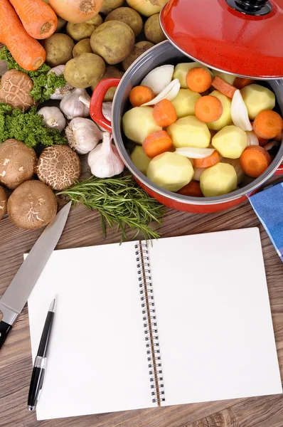 Cook book with vegetables and casserole dish — Stock Photo, Image