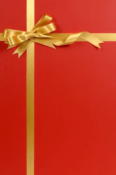 Christmas gift border gold ribbon bow red background vertical — Stock Photo, Image