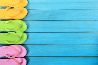 Parmak arası terlik mavi arka plan ağaç plaj güverte üzerinde yan kenarlık satırı