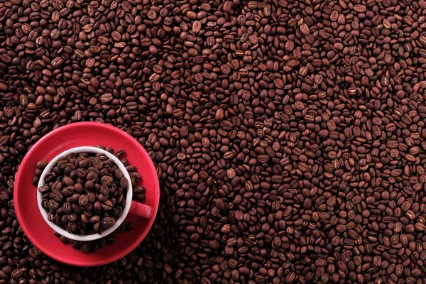 Красная чашка кофе с фасолью сверху — стоковое фото