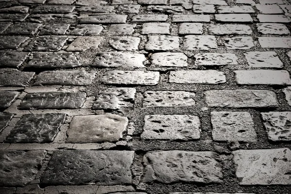 Vecchio ciottolo pietra strada superficie pavimentazione buio notte fondo textu — Foto Stock