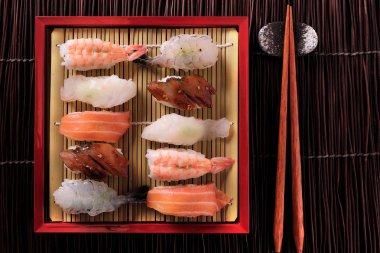 Japon suşi çeşitli ürün yelpazesine kırmızı bambu tepsi yemek çubukları