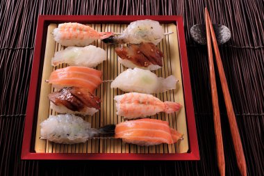 Japon suşi çeşitli ürün yelpazesine kırmızı bambu tepsi yemek çubukları