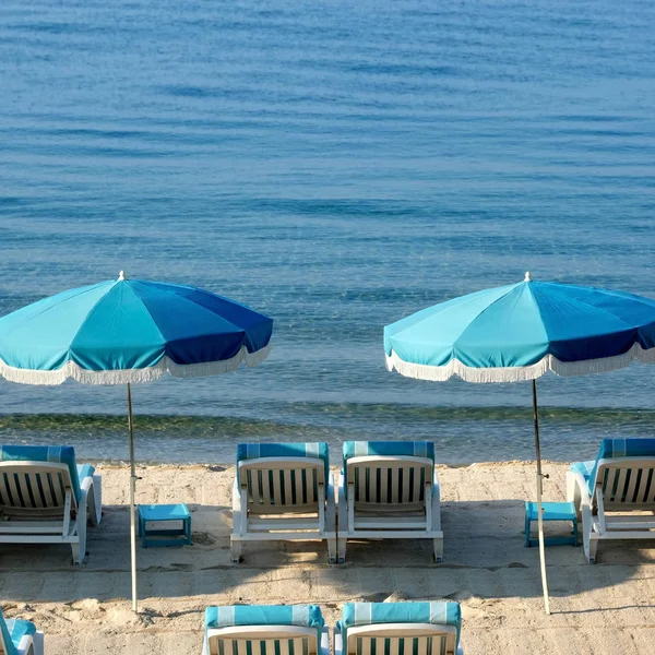 Śródziemnomorskiej plaży parasol krzesła relaksujący — Zdjęcie stockowe