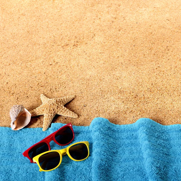 Fronte spiaggia con occhiali da sole, asciugamano, stelle marine e mare — Foto Stock