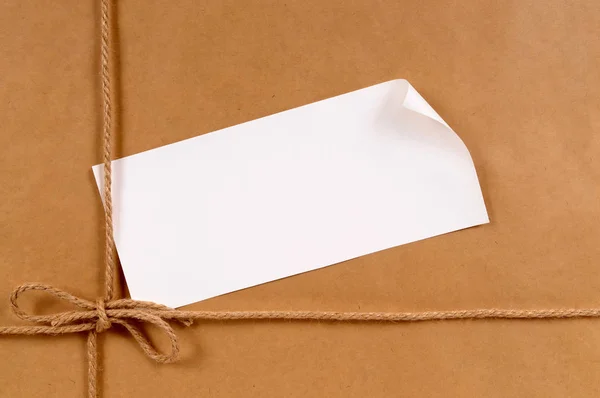 Achtergrond Van Bruin Papier Pakket Met Gekrulde Hoek Label — Stockfoto