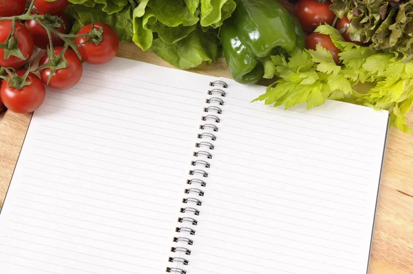 Salad with blank recipe book and chopping board — Stock Photo, Image