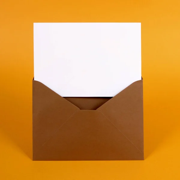 Sobre marrón con tarjeta de mensaje en blanco — Foto de Stock