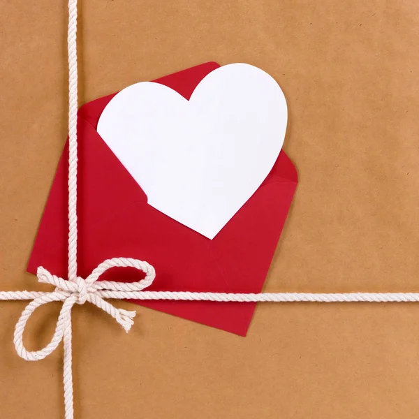 Regalo de San Valentín con tarjeta de forma de corazón blanco, sobre rojo, b — Foto de Stock