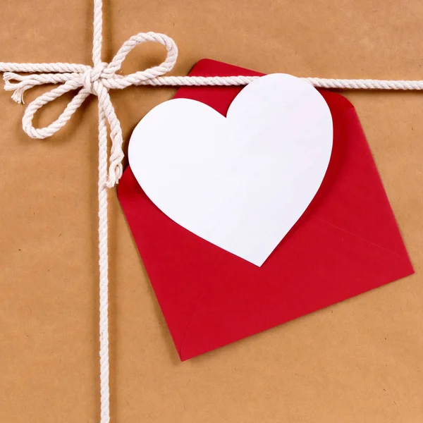 Regalo de San Valentín con tarjeta de forma de corazón blanco, sobre rojo, b —  Fotos de Stock