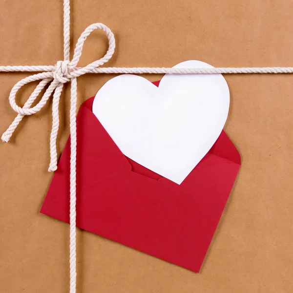Regalo de San Valentín con tarjeta de forma de corazón blanco, sobre rojo, b — Foto de Stock