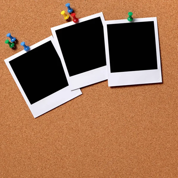 Três fotos em branco presas a uma placa de cortiça — Fotografia de Stock