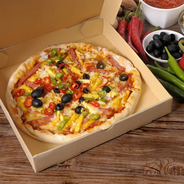 Свежеиспечённая пицца в коробке с ингредиентами . — стоковое фото