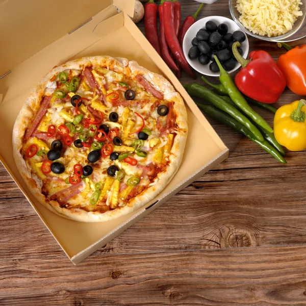 Pizza recién horneada en caja de entrega con ingredientes . — Foto de Stock