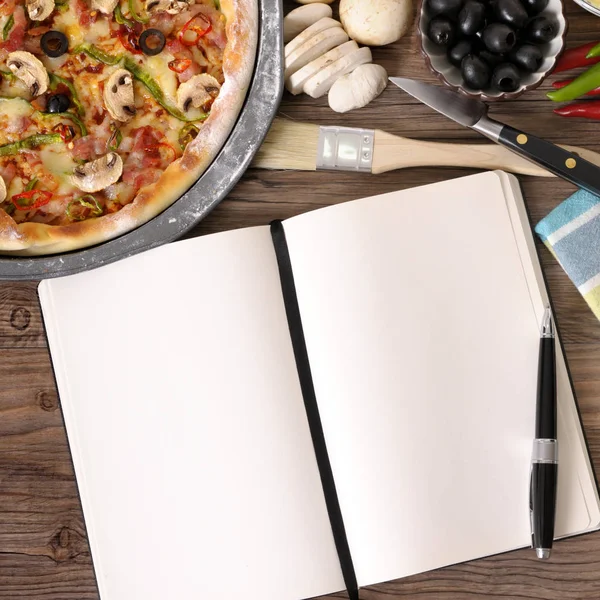 Freshly baked Pizza with cookbook — Stock Photo, Image