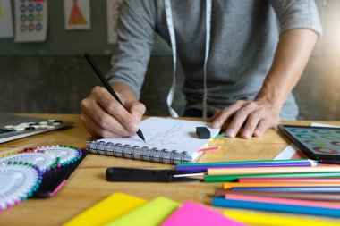 genç erkek moda tasarımcısı işe kumaş bez ile masaya 