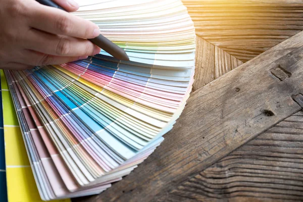 木のテーブルで プロジェクトの最高の色選択のための色トーン紙を扱うグラフィック デザイナー — ストック写真