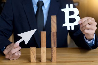 iş adamı aşağı veya yukarı bitcoin değeri göstermek için ahşap blok oyun ve bitcoin modeli kullanın