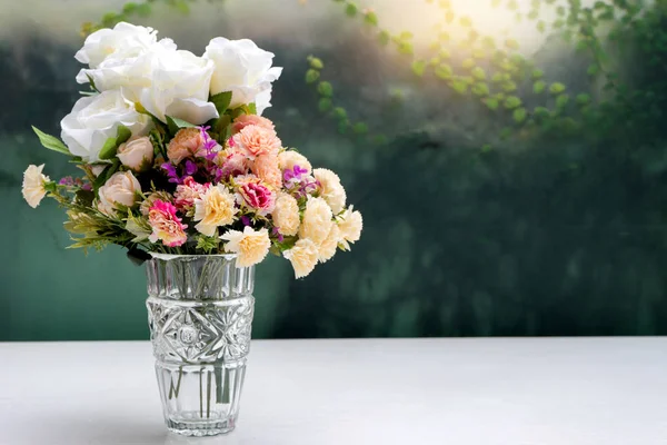 Fleur dans un vase en verre sur table blanche — Photo