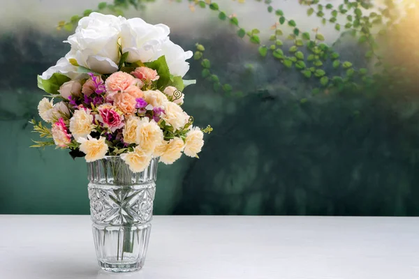 Fleur dans un vase en verre sur table blanche — Photo