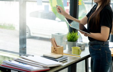 İş adamı ve kadın masada oturup ofisteki bilgisayar laptopuna bakıyorlar. Borsa yatırımından ya da müşteriyle konuşmaktan bahsediyorlar.
