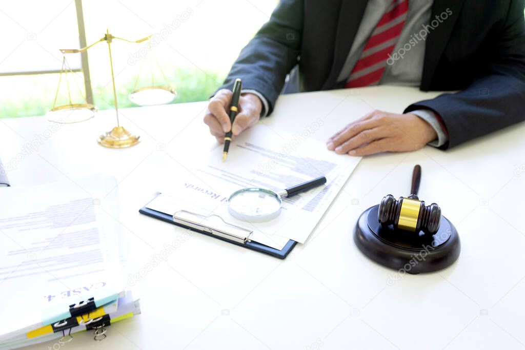 Lawyer or judge use magnifier glass look to the paper for inspection examination to the law case