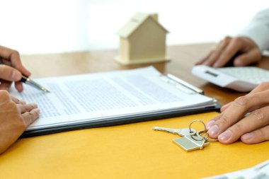 Masa kağıdı tabelasında, bir emlakçı ev anahtarını hazırlıyor. Kiralık ya da satılık.
