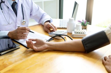 Doktor, kan basıncını ölçün. Klinikteki genç hasta.